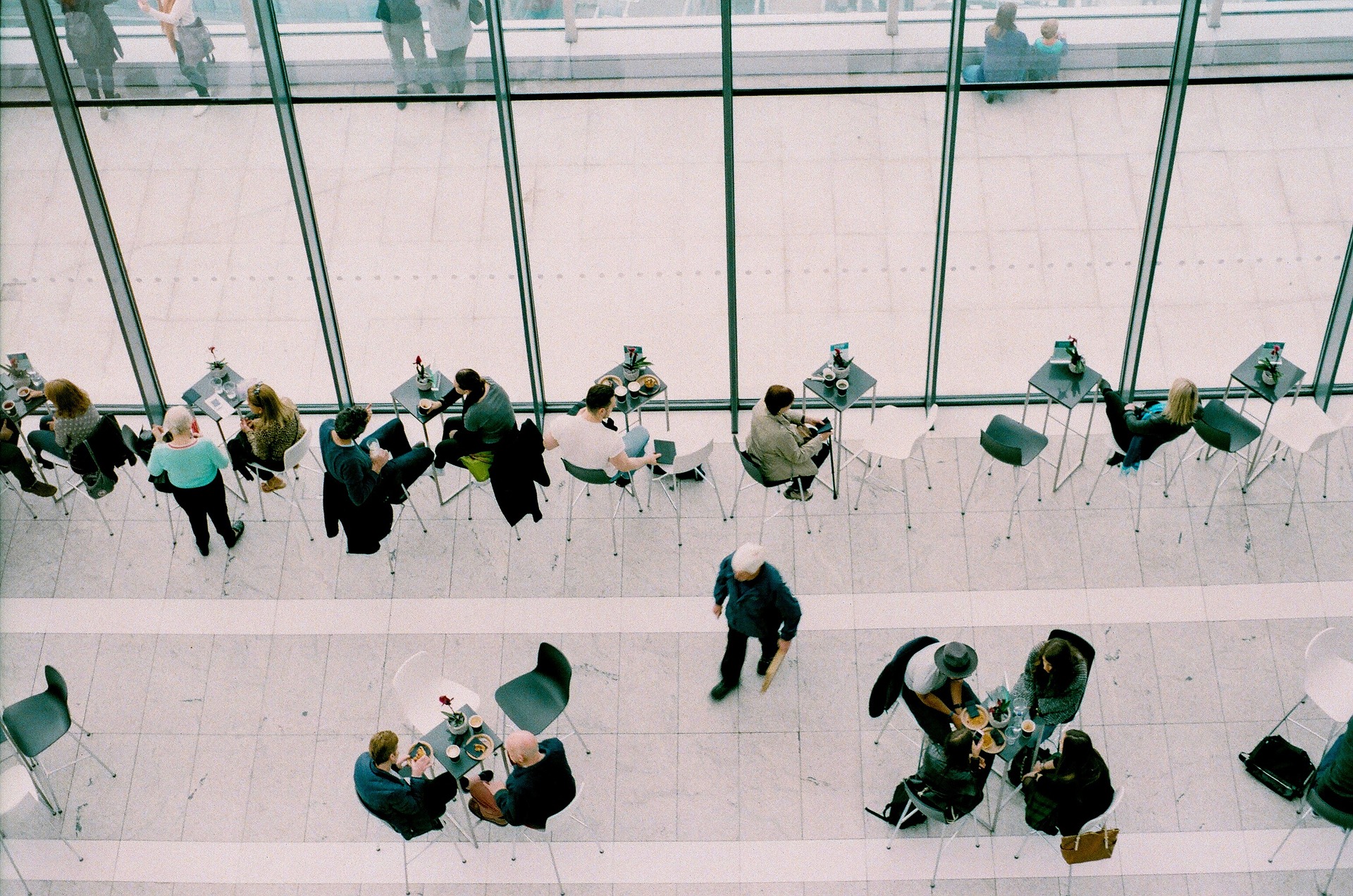 Aerial view of meetings in a coffee shop highlighting the importance of professional communication