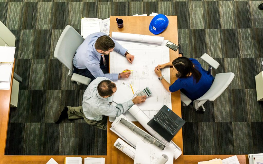 Aerial view of a team working on a work plan showing that professional communication is essential for team success